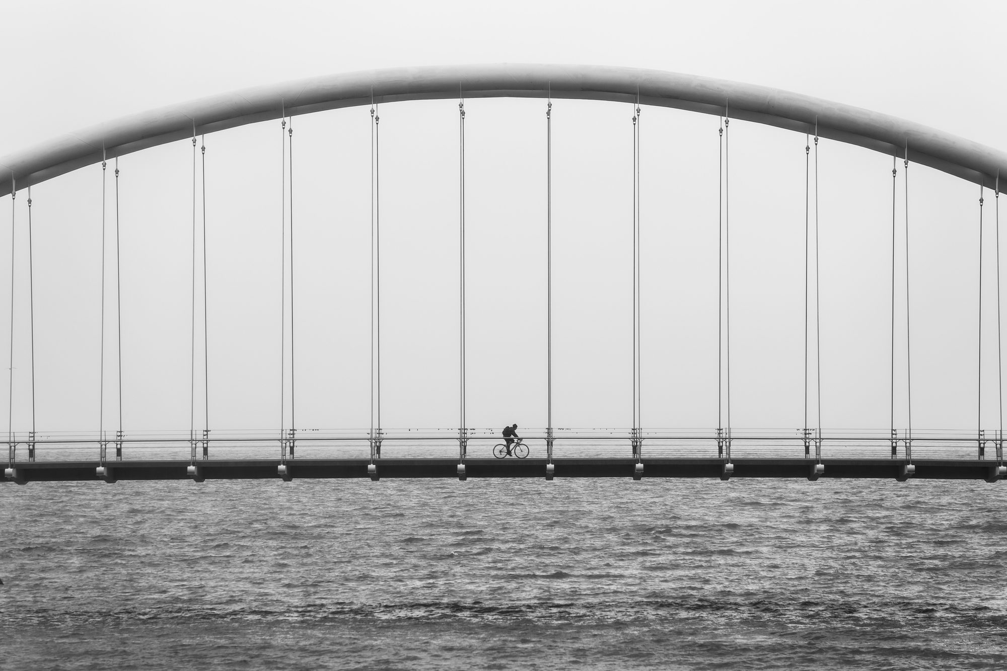 Eine Person überquert eine Brücke im Nebel